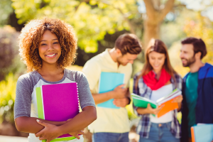 Jovens universitários sorrindo em ambiente ao ar livre, representando a escolha entre bacharelado, tecnólogo e licenciatura — cada um com seu estilo, objetivos e tipo de graduação ideal. 