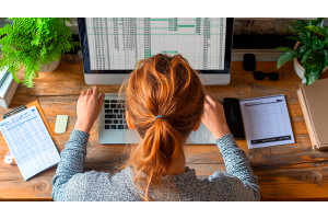 Jovem assistente administrativo trabalha em planilhas no Excel, aplicando fórmulas básicas como SOMA e PROCV. A imagem representa o uso prático do Excel no dia a dia do escritório, essencial para quem busca um estágio ou quer se destacar na área administr