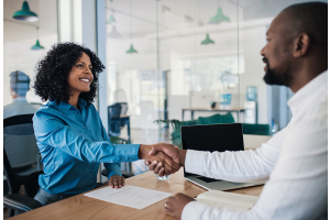 Imagem de uma entrevista de emprego que revela o que os recrutadores observam além do currículo: postura, atitude e confiança na interação pessoal.